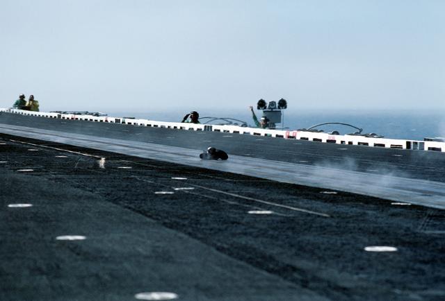 Deckedge crewmen cheer as the catapult officer`s boots travel down the No. 1 catapult aboard the aircraft carrier USS MIDWAY (CV