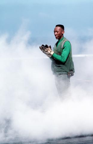 Aviation Boatswain`s Mate 3rd Class Ronnie Josey applauds, after watching the launch of the catapult officer`s boots. - 24 SEP 1