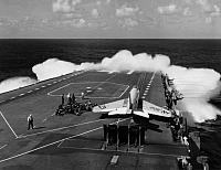Wave action while a VF-21 Freelancer F3H Demon waits on the cat.