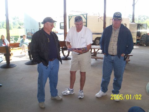 Bob Shultze, AJ "Fabio" Deese proving he can read to Rudy "Ruby" Wortham - 2007 Reunion
