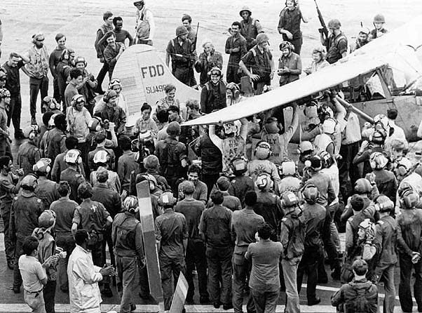 Crew surrounds Bird Dog after successful landing - USN Photo