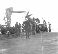 Skyraider held by crane after taxiing over the port side into the catwalk