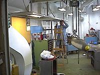 Bob Solomon (LCDR AO Ret.) painting the AME Shop (Space C-150) on the ship, with MK-82 Mod 1(inert) on hoist making ready for di